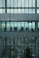 people on the bridge near the building