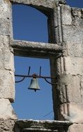 Bell in the ruin of aged church at blue sky, France