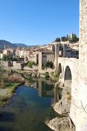 picturesque old town at calm River among the plants and mountains