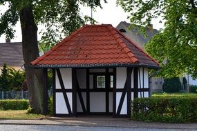 Timber Framed Building at road beneath tree
