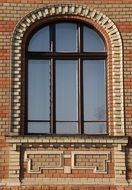 large window on the facade of a brick building