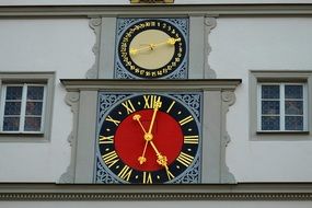 red clock on the facade of the building