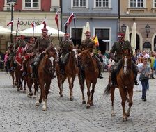 people riding horses with flags in poland