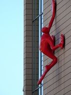 modern red sculpture on a building wall