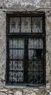 black and white photo of a window with metal bars in Greece