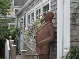 sculpture of a smoker at the wall of the house