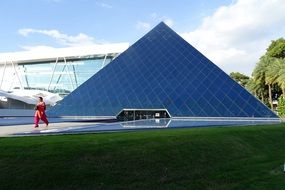 man goes near the glass pyramid