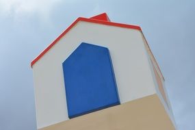 white cottage with blue door and red roof