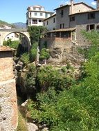 old house with a bridge in green areas, italy