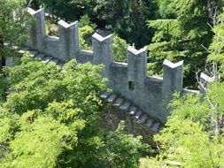 walls of a castle among green trees in san marino