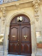 beautiful wooden door decorated with statues of atlants