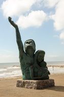 couple with child, statue on the beach, usa, texas, galveston