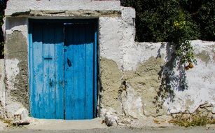 blue wooden door on stone wall