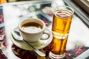 a glass near a cup of coffee