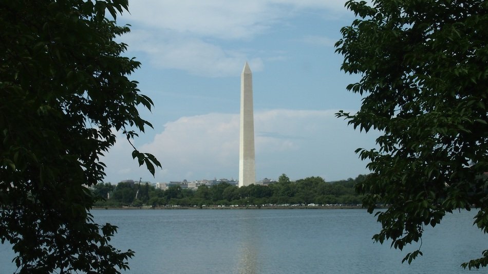 monument on the lake behind the trees