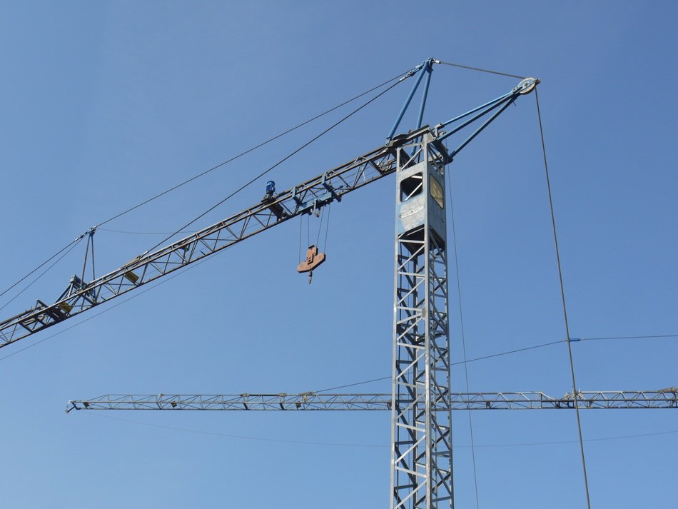 two Construction tower Cranes at sky
