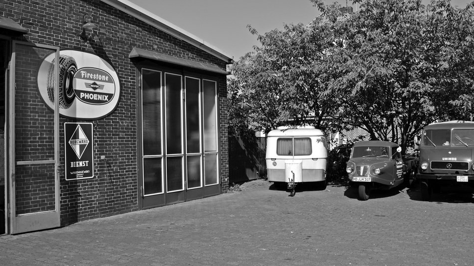 black and white photo of cars near the building