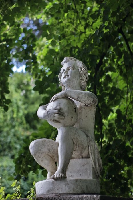 sculpture of a boy with a ball in the park