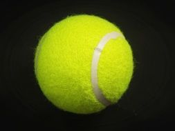 yellow tennis ball on black background