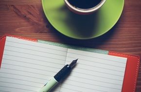 cup of coffee and opened notebook