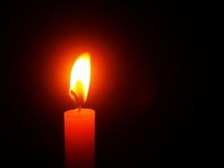 burning candle on a black background