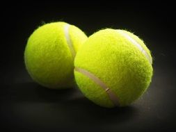yellow tennis balls on a dark surface