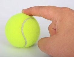 hand touching tennis ball
