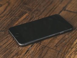 black iPhone on the wooden table