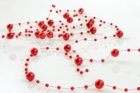red beads of different sizes on a thin string