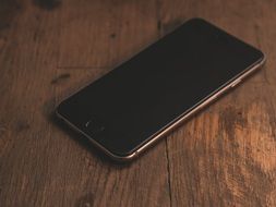 black smartphone on the wooden table