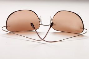 dark glasses lie on a white surface