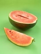 half a watermelon and a slice of watermelon on a green background