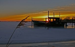 frozrn fishing boat on the lake in winter