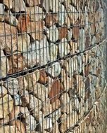 stone wall covered by metal wire