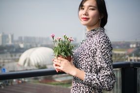 cute asian model with potted flowers