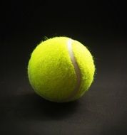 yellow tennis ball on the black background