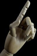 indicating wooden hand on black background