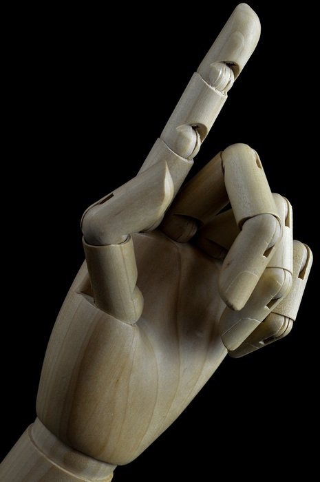indicating wooden hand on black background