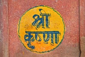 inscription on the yellow circle on the wall