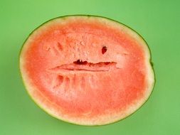 half seedless watermelon on green background