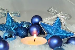 blue Christmas baubles and lit candle