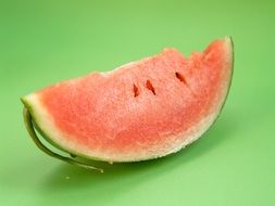 a slice of pink watermelon on a green background