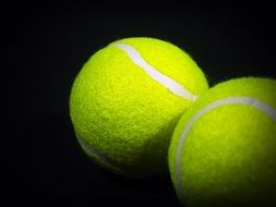 yellow tennis balls on a black background close-up