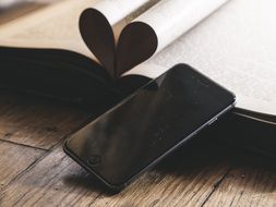 black smartphone and opened book