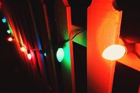 colorful light garland on the wooden fence