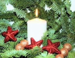 burning candle on fir branches