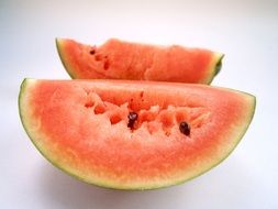 two watermelon slices on a white surface
