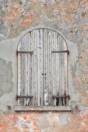 wooden window shutters on the old weathered wall