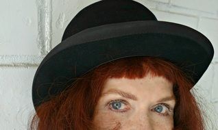 portrait of red-haired woman in a black hat
