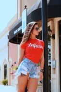 Young Fashion Woman in denim shorts and sunglasses